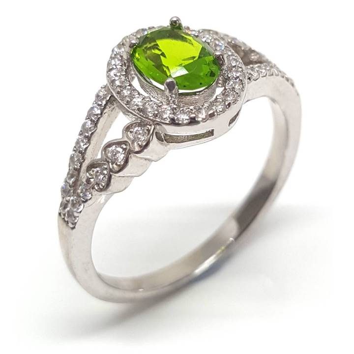 Feminine and stylish, this citrus leaf yellow-green coloured central stone dress ring of approx. 10mm top width will make you feel truly special. Features a 0.76 carat oval cut and shape peridot coloured cubic zirconia (7mm x 5mm) central stone in a 4-prong setting. Accented with a surrounding halo and a striking split shank band with further glittering white cubic zirconia stones. The split shank tapers to a 2mm wide band at the base and these dress rings have an approx 2.5 gram overall weight. This finest quality rhodium plated 925 sterling silver jewellery will add sparkle to any outfit.